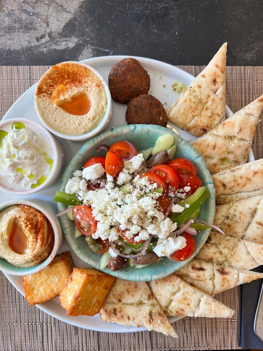 Delicious Greek meze platter featuring fresh vegetables, dips, and pita bread, ideal for sharing.